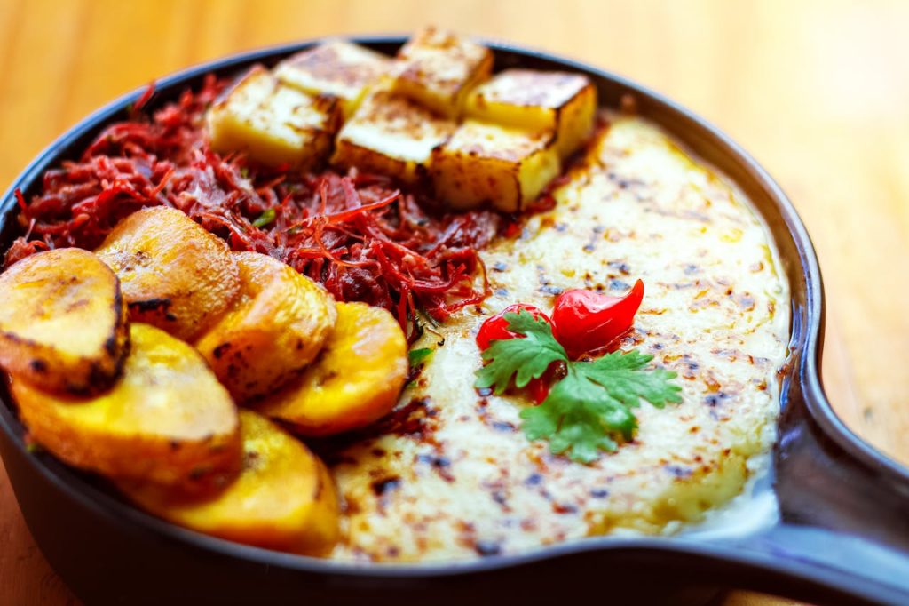 Savor a hearty meal with fried plantains, cheese, and grilled vegetables. Perfect for a vibrant lunch.
