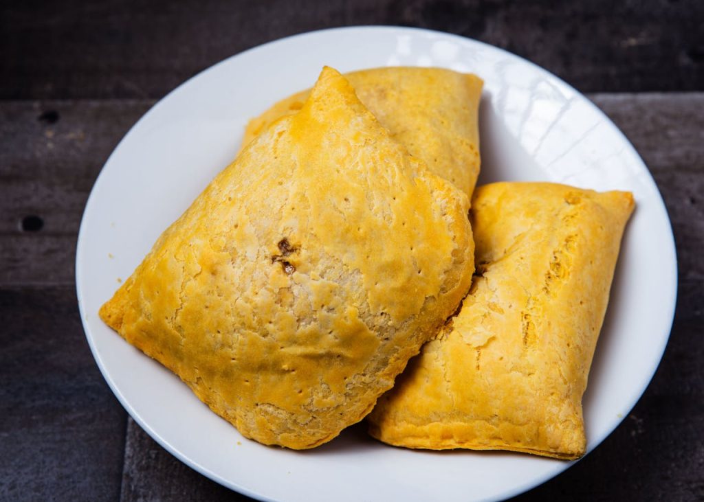 Delicious homemade Jamaican patties on a display plate, perfect for lunch or dinner.